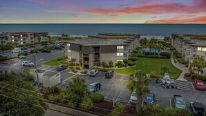 A coastal hotel with multiple buildings, a parking lot, and a view of the ocean. - Ocean Forest Villas Unit D304 - Ocean view (Myrtle Beach)