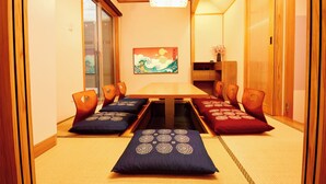 A traditional Japanese room with tatami flooring, a low table, and cushions. - Asakusa Ryokan Vacation Rental Tokyokoso (Tokyo)