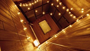 A room with wooden paneling, a visible bathtub, and string lights. - Asakusa Ryokan Vacation Rental Tokyokoso (Tokyo)