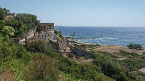 A coastal historical site with stone buildings, a pathway, and a view of the sea. - Stylish Villa w/Private Pool & BBQ near Elafonissi (Chania)