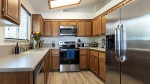 Eine moderne Küche mit Holzausstattung, Edelstahlgeräten und einem großen Kühlschrank.