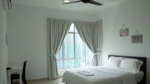 Un dormitorio con cama, escritorio y ventana con cortinas.