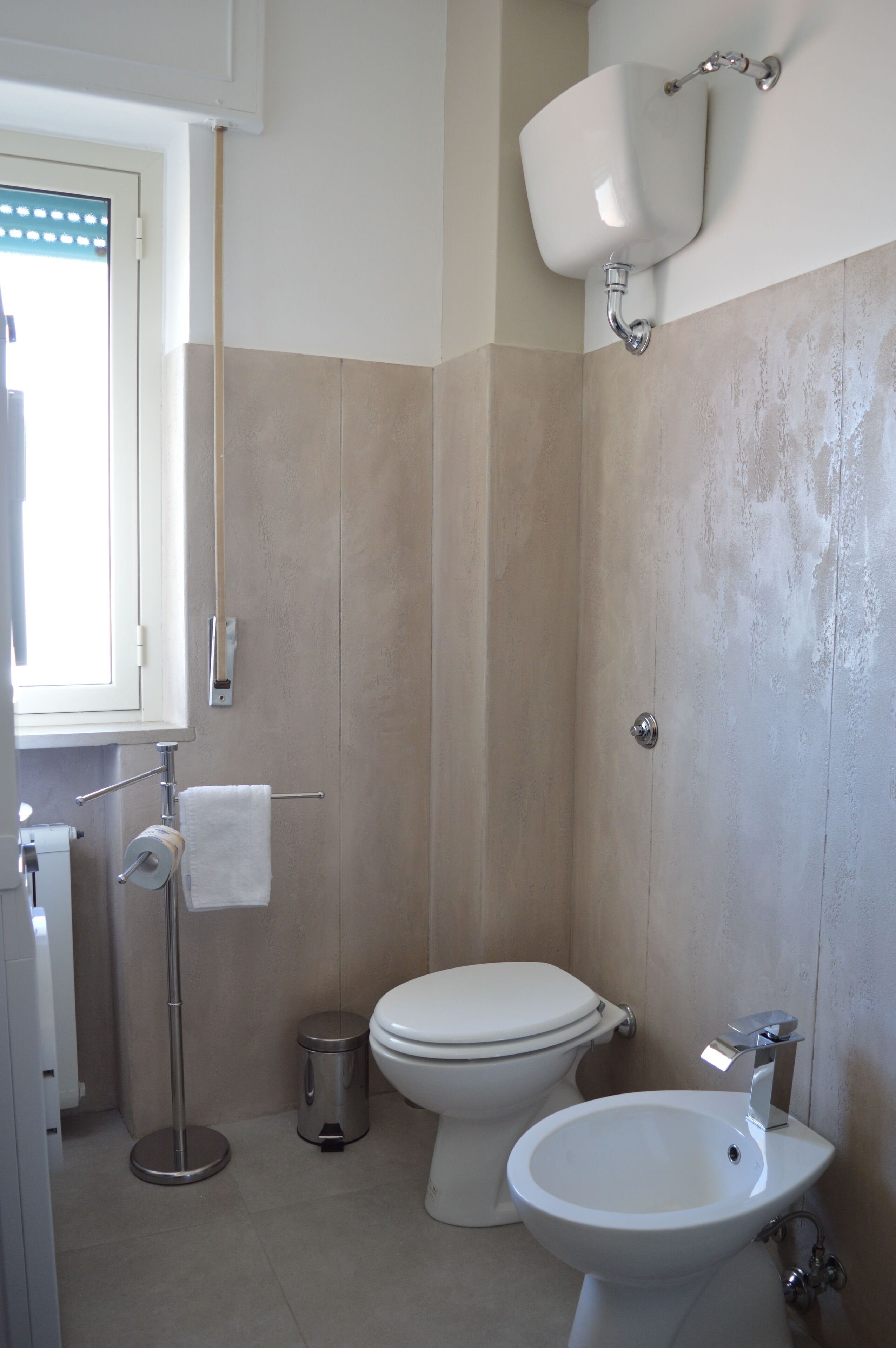 A bathroom with a toilet, bidet, and sink.