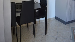 Una habitación con una mesa de comedor y sillas, aire acondicionado y una pantalla mural que muestra el logotipo de 'EMERELLA'.
