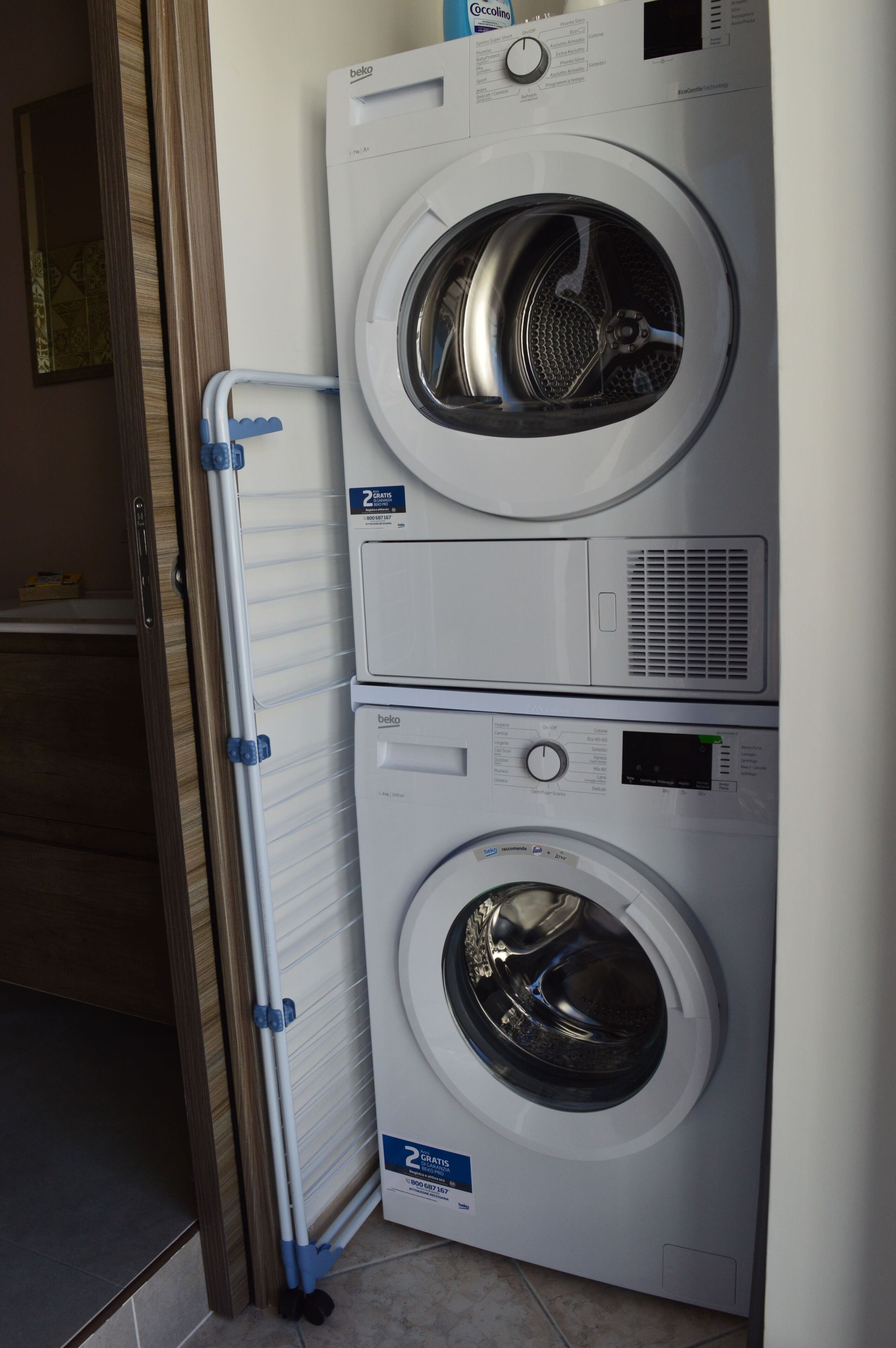 Una lavadora y secadora apiladas con un panel de control y una salida de ventilación.