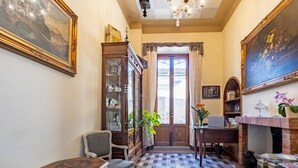 Una stanza con pavimento a scacchi, un armadio in legno, una scrivania, una sedia e un camino.