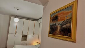 A bedroom with a bed, a wardrobe, and a painting on the wall. - Grand House  (Tirana)