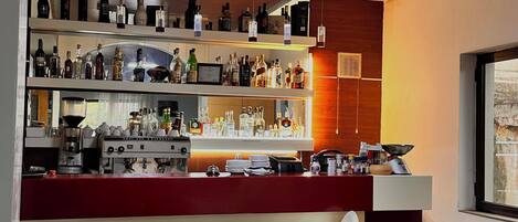 A bar area with shelves of bottles, a coffee machine, and a bar counter.