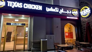 The exterior of a restaurant named Texas Chicken with a 'Welcome' sign and outdoor seating area. - Sparkle View Hostel (Dubai)