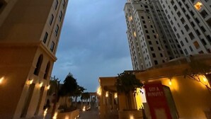 A view of tall residential buildings with multiple floors and balconies, under a twilight sky. - Sparkle View Hostel (Dubai)