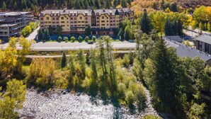 A multi-story hotel with a central courtyard, surrounded by dense forest and hills.