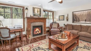 A living room with a fireplace, leather chairs, a sofa, and a coffee table.