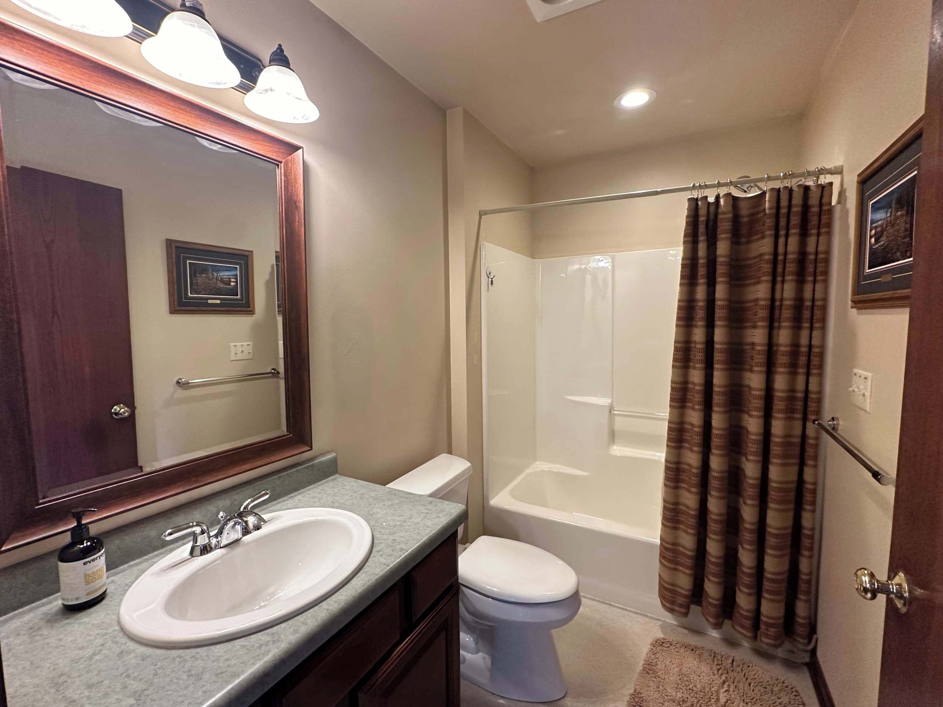 A bathroom with a sink, toilet, and shower.