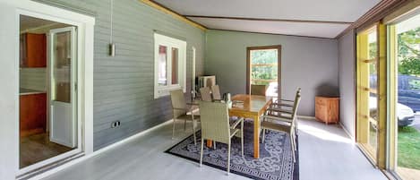 Een eetgedeelte met een tafel, stoelen, een vloerkleed en uitzicht op de omgeving.