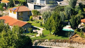 A residential area with stone buildings, a swimming pool, and lush greenery. - Casa S. Miguel Arcanjo - T5 (Caniçada)