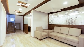 Un intérieur moderne avec un plafond en bois, un canapé beige et une cloison en verre ornée de motifs hexagonaux.