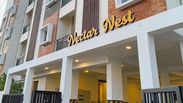 Un immeuble à plusieurs étages, avec une enseigne indiquant « Nectar West » à l’entrée.