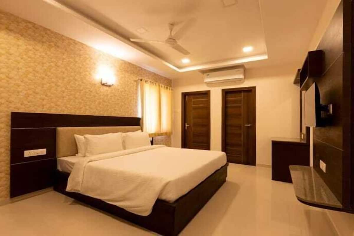 A bedroom with a bed, nightstands, a ceiling fan, and a wardrobe.