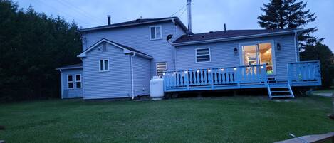 A two-story house with a blue porch and a visible garage door.