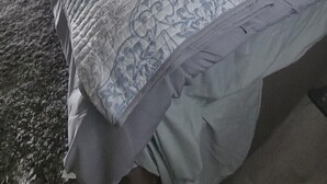 Un dormitorio con una cama grande, una mesita de noche con una lámpara, un reloj en la pared y un cuadro enmarcado sobre la cama.
