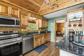 A kitchen with wooden cabinets, stainless steel appliances, and a coffee bar.
