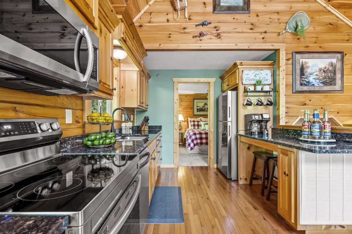 Une cuisine avec des meubles de rangement en bois, une cuisinière et un réfrigérateur.