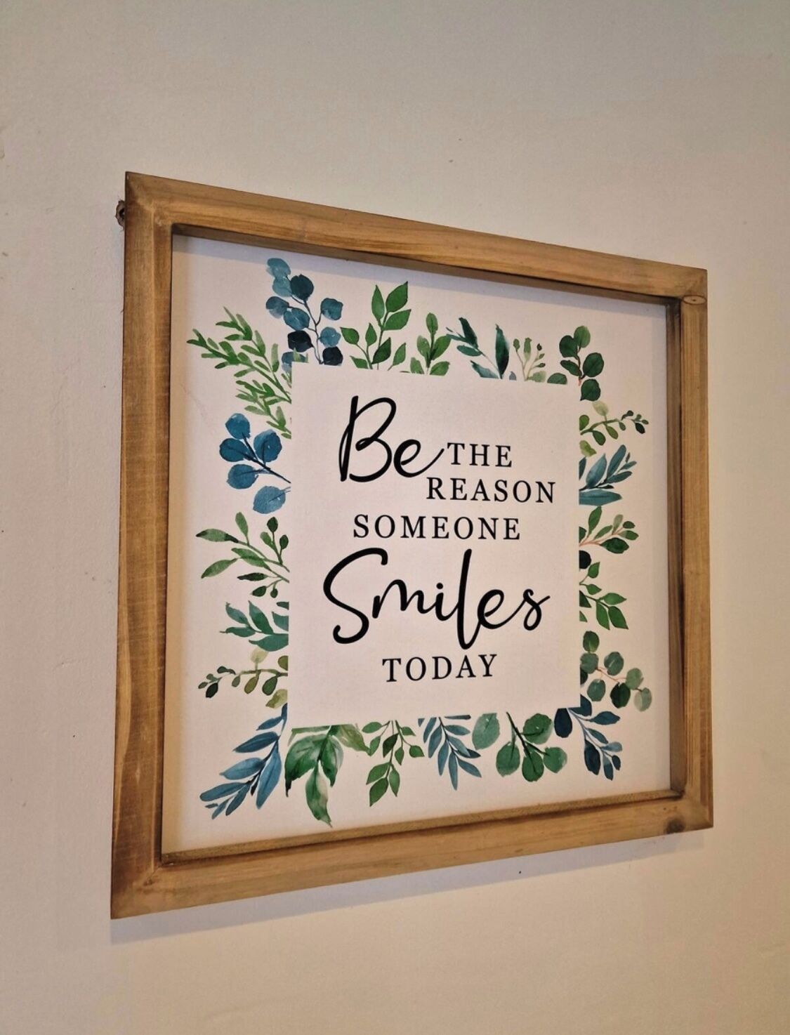 A framed inspirational quote surrounded by a decorative border of leaves.