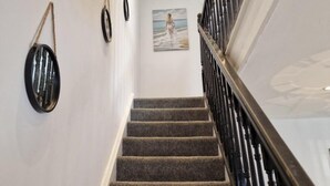 A staircase with carpeted steps and a black railing. - Charming 3 Bedroom House in Sheffield (Sheffield)
