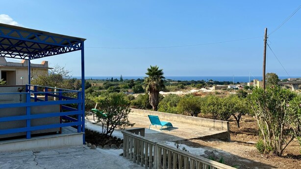 A residential area with a blue metal structure, a concrete pathway, and a view of the sea. - Vacation home with beautiful sea view near Guidaloca, Scopello and the Zingaro (Castellammare del Golfo)
