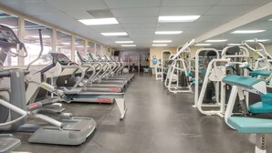 A gym with treadmills, elliptical machines, and weight machines.