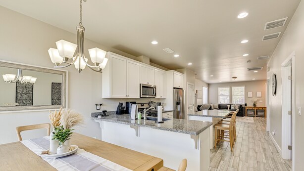 A modern kitchen with white cabinets, a granite countertop, and stainless steel appliances. - Family-friendly Flagstaff Home Near Hiking Trails! (Flagstaff)
