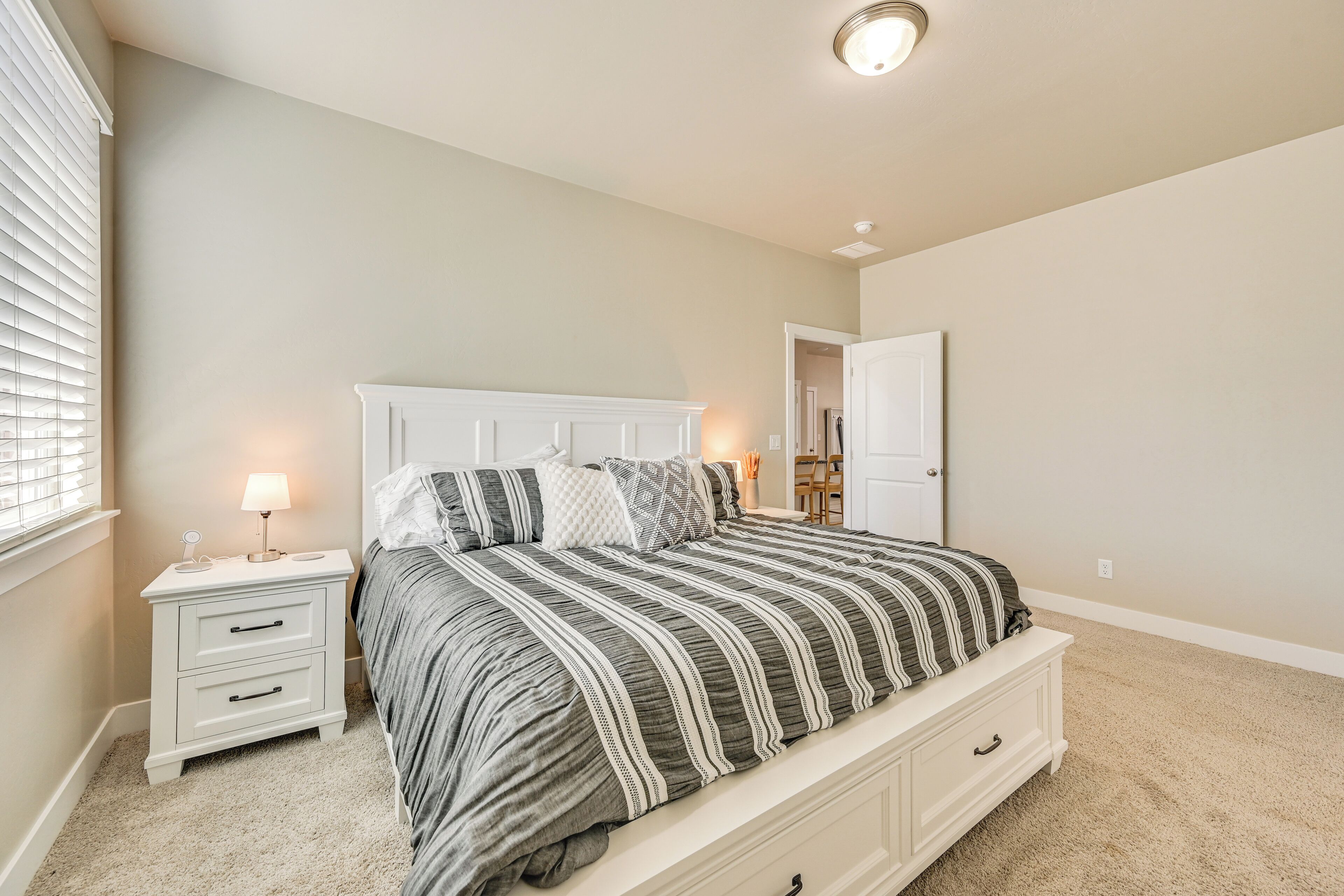 A bedroom with a bed, nightstand, and a lamp.