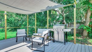 An outdoor patio with a grill, two chairs, and a canopy. - Centrally Located Merritt Island Cottage w/ Deck! (Merritt Island)
