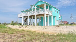 A two-story house with a balcony and a covered porch. - Hot Tub, Beach Access! Bay-view Gilchrist Retreat (Port Bolivar)