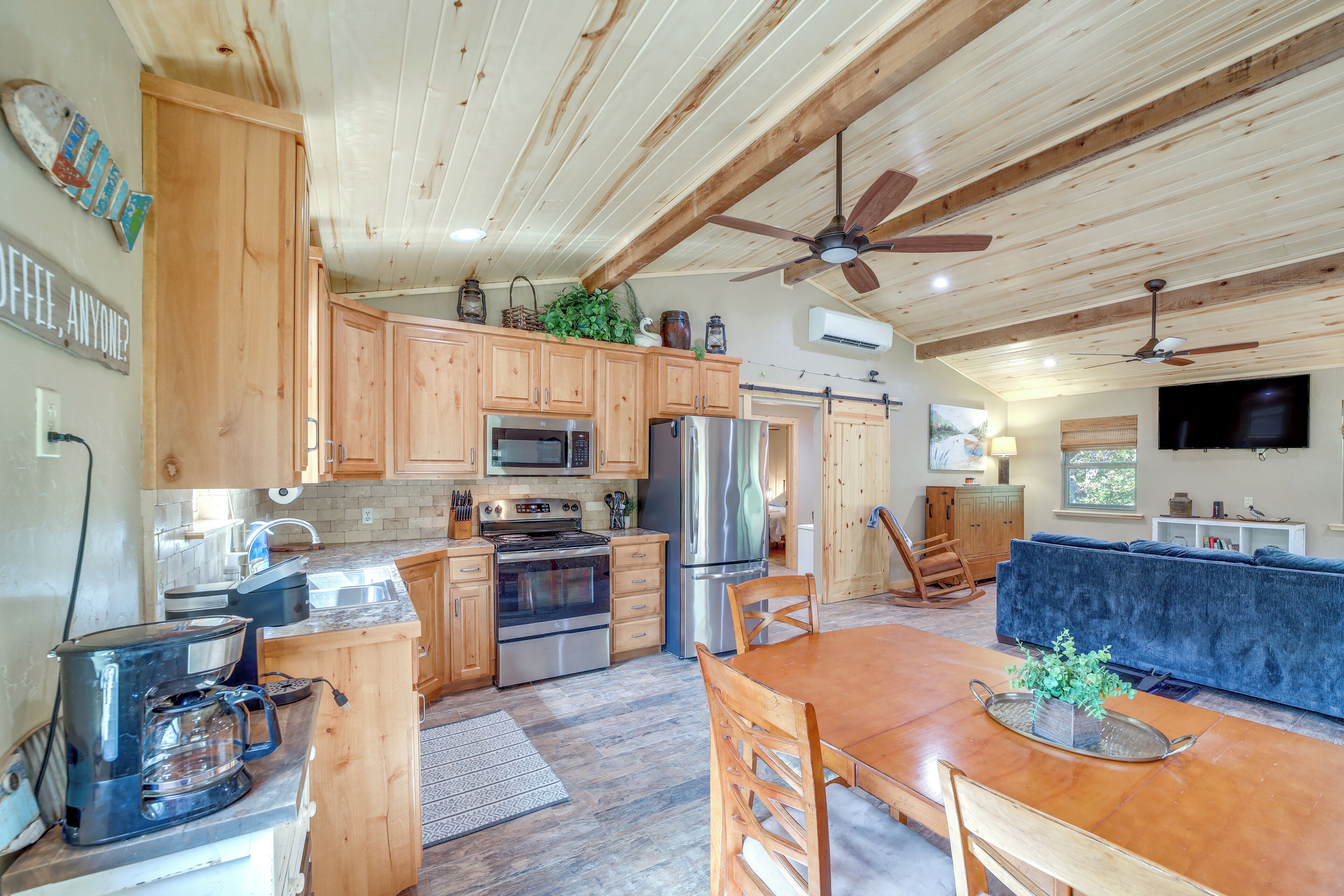 A spacious kitchen with wooden cabinets, stainless steel appliances, and a dining area with a wooden table and chairs.