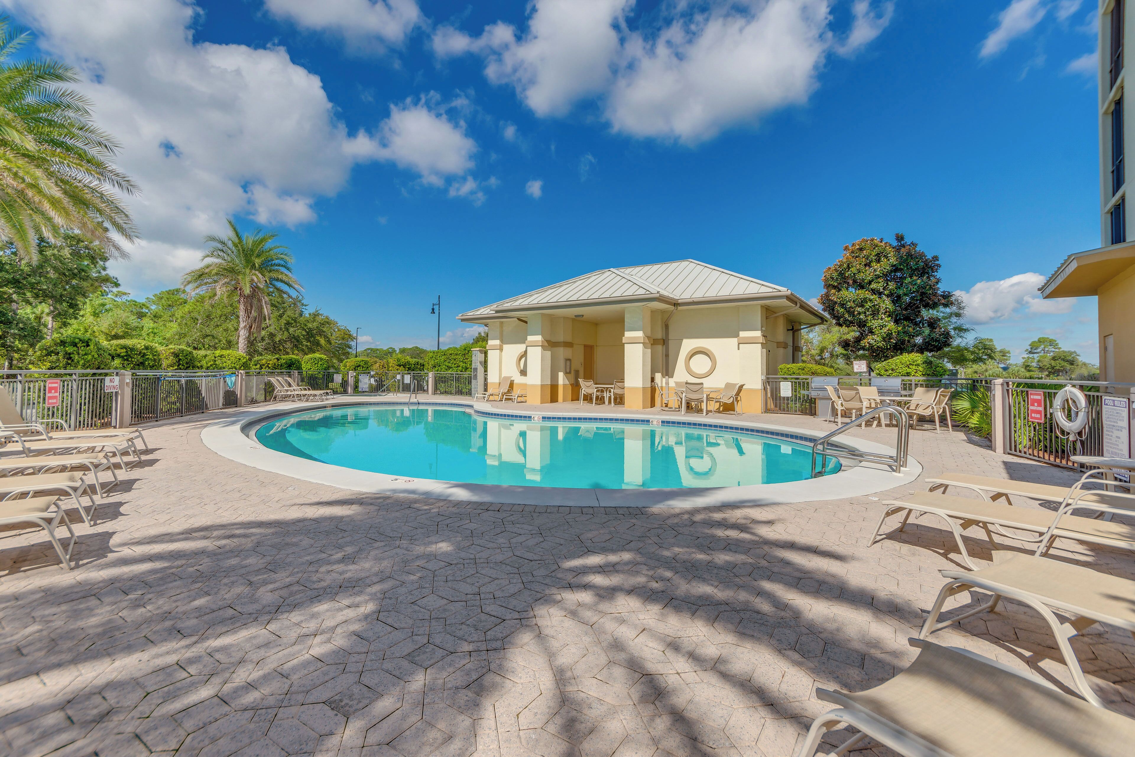 A swimming pool with lounge chairs and a building in the background.