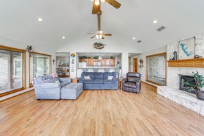 A spacious living room with a large sectional sofa, a leather armchair, and a fireplace. - Rhodes Retreat w/ Dock on Cedar Creek Lake! (Malakoff)