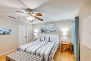 A bedroom with a bed, a ceiling fan, a nightstand with a lamp, and artwork on the walls. - Rhodes Retreat w/ Dock on Cedar Creek Lake! (Malakoff)