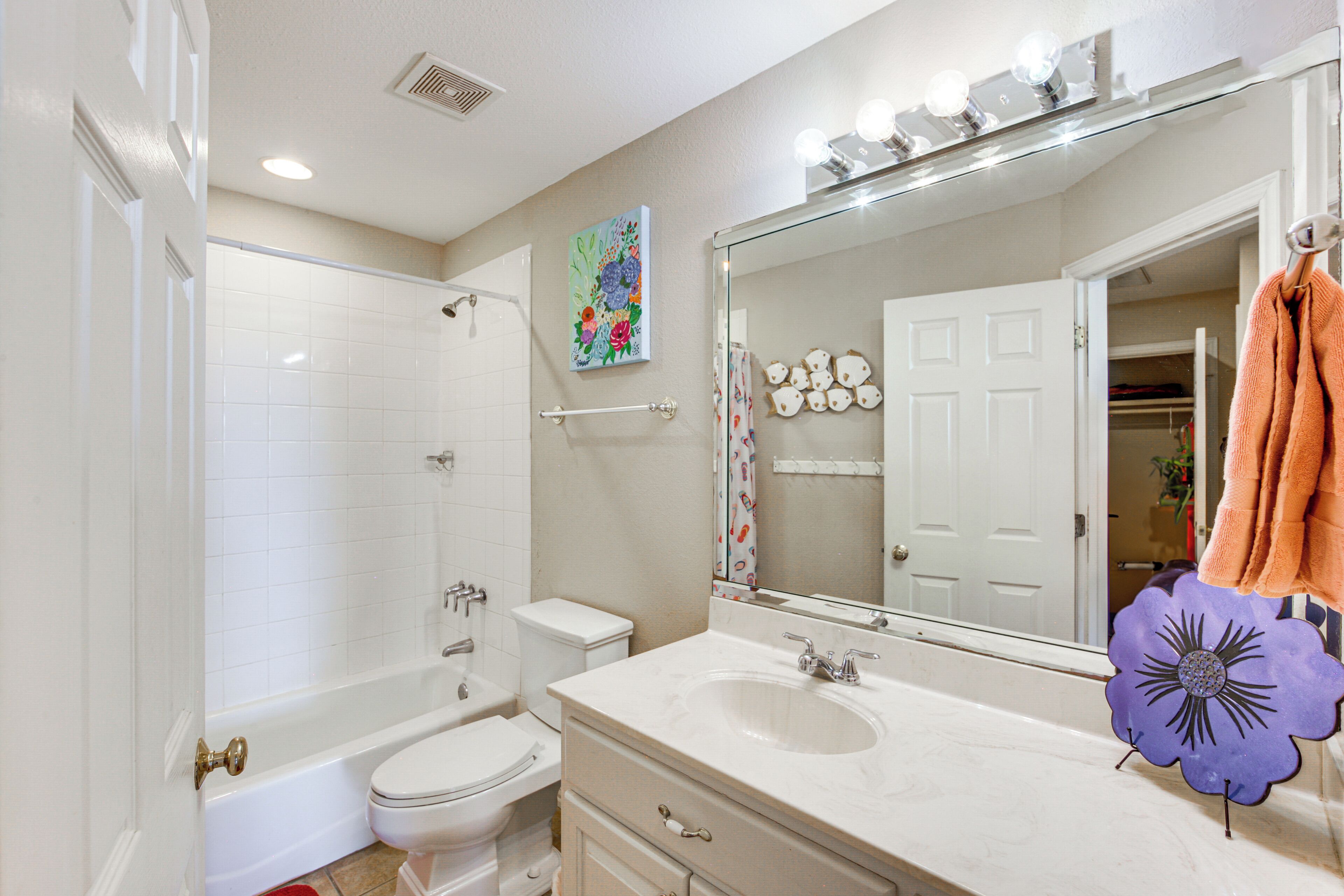 Une salle de bain avec une baignoire, des toilettes, un lavabo et un grand miroir.