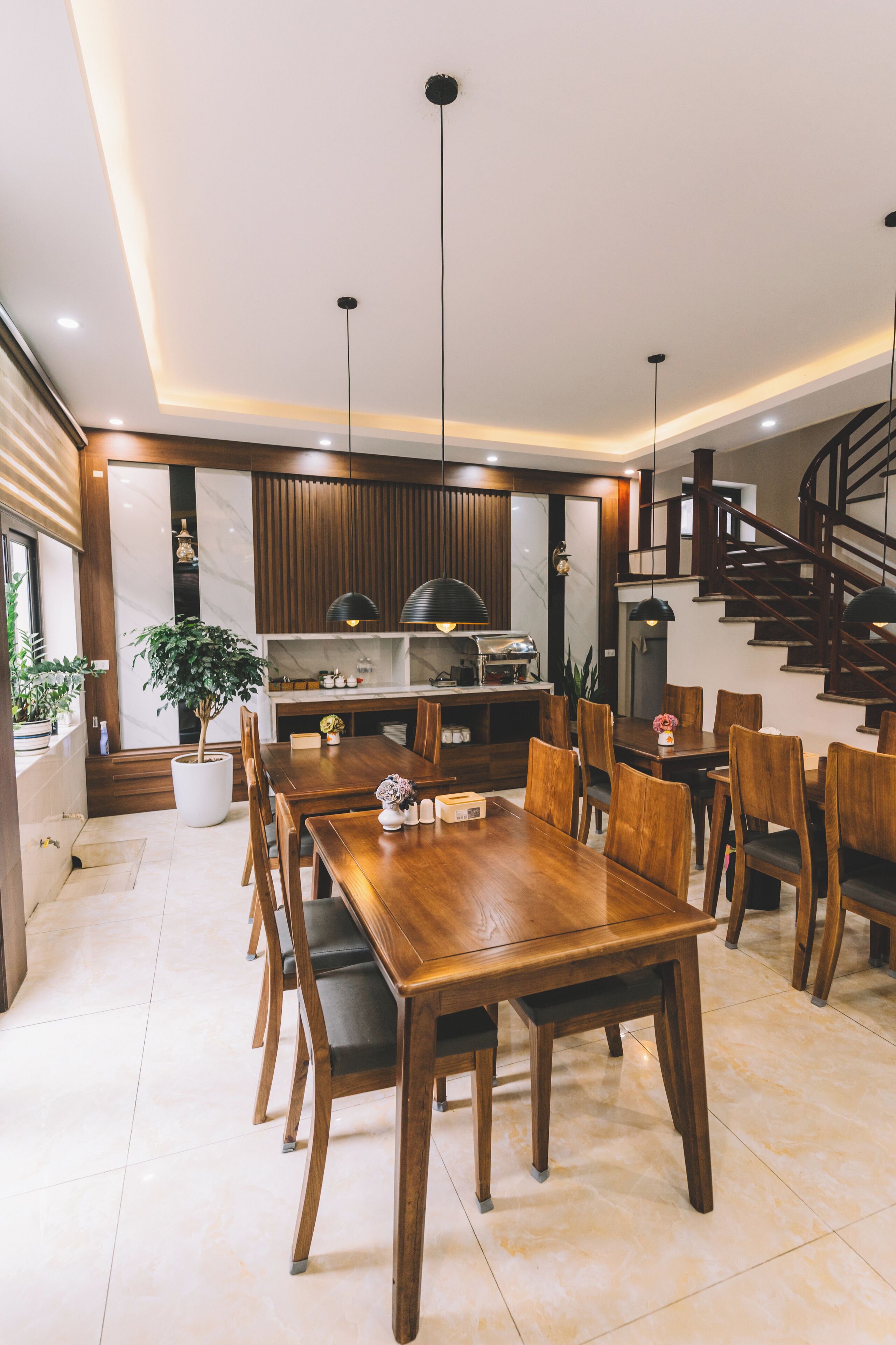 Une cuisine moderne dotée d’une cuisinière intégrée, de meubles en bois et de luminaires suspendus.