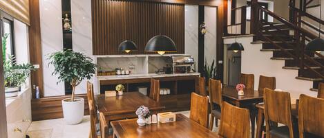 Une cuisine moderne dotée d’une cuisinière intégrée, de meubles en bois et de luminaires suspendus.