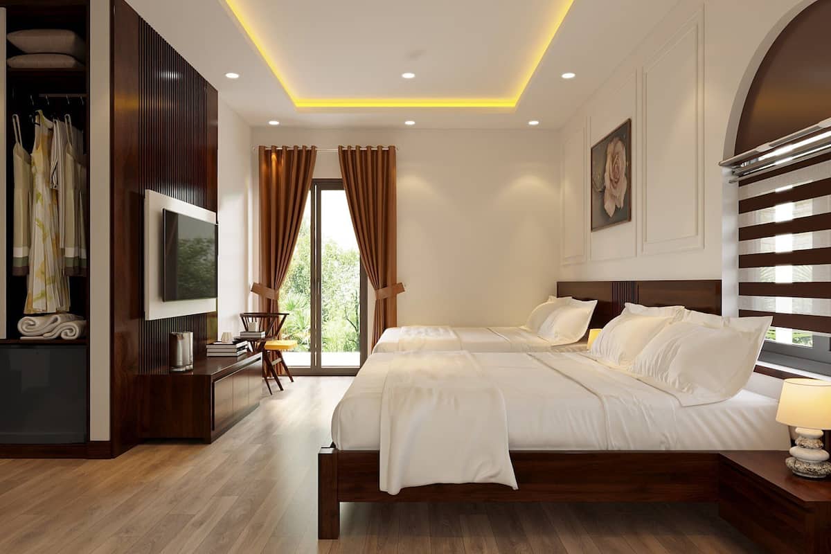 A modern bedroom with a large bed, a TV, and a wardrobe.