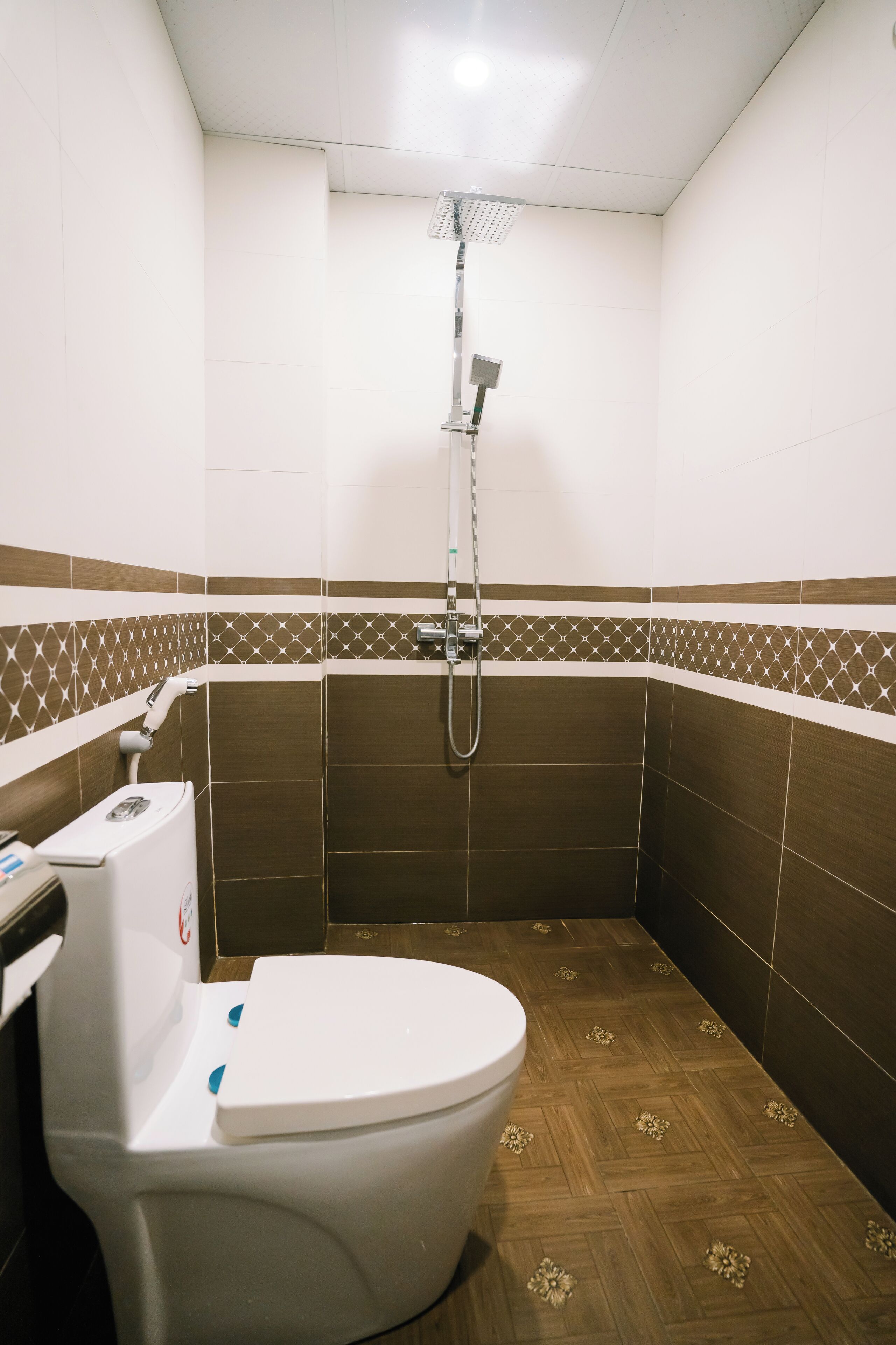 A small bathroom with a toilet, shower, and tiled walls.