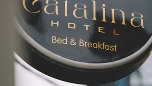 Un letrero circular con el texto 'Catalina Hotel Bed & Breakfast' y un logotipo de rosa.