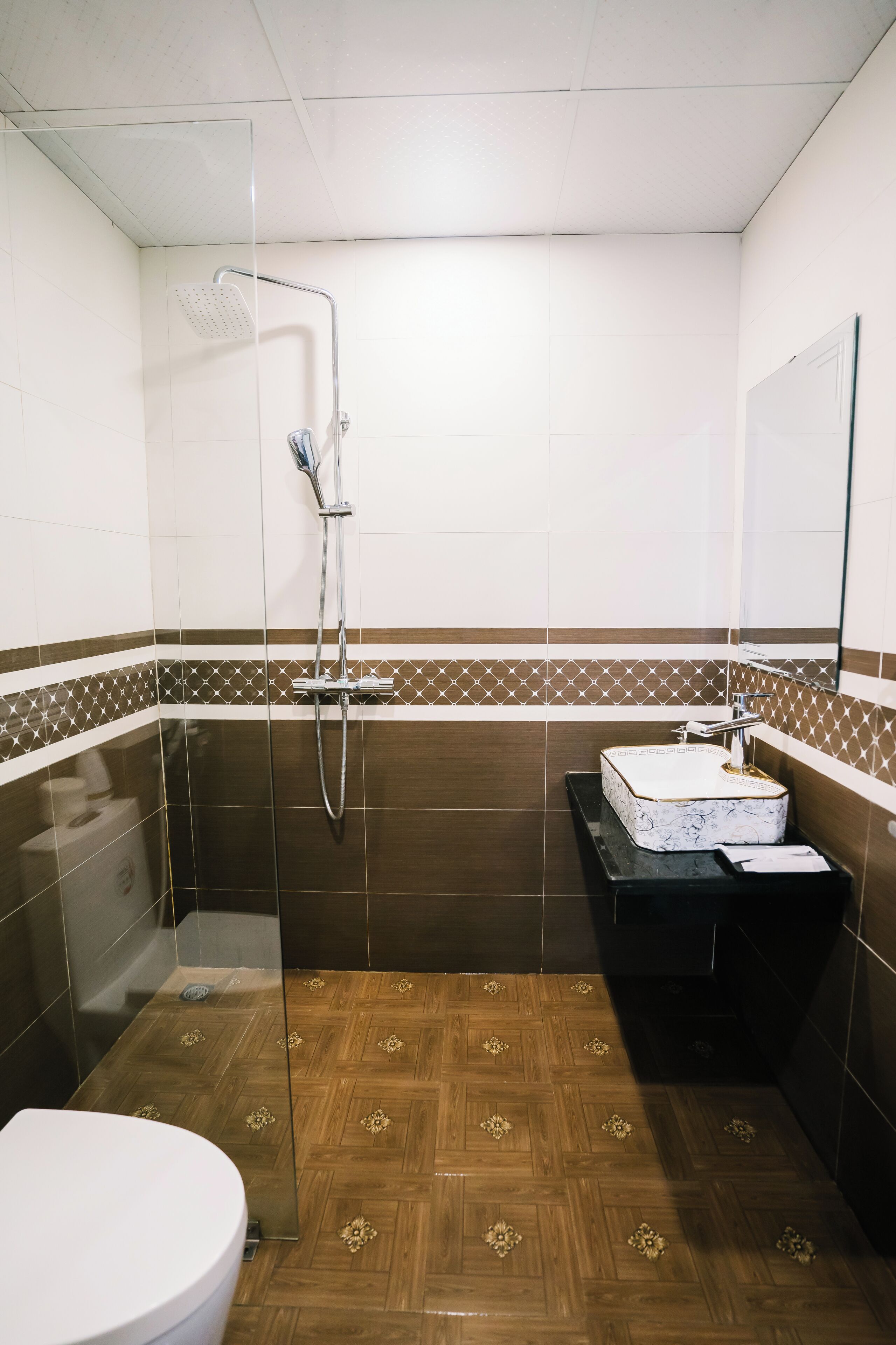 A small bathroom with a shower, toilet, and sink.