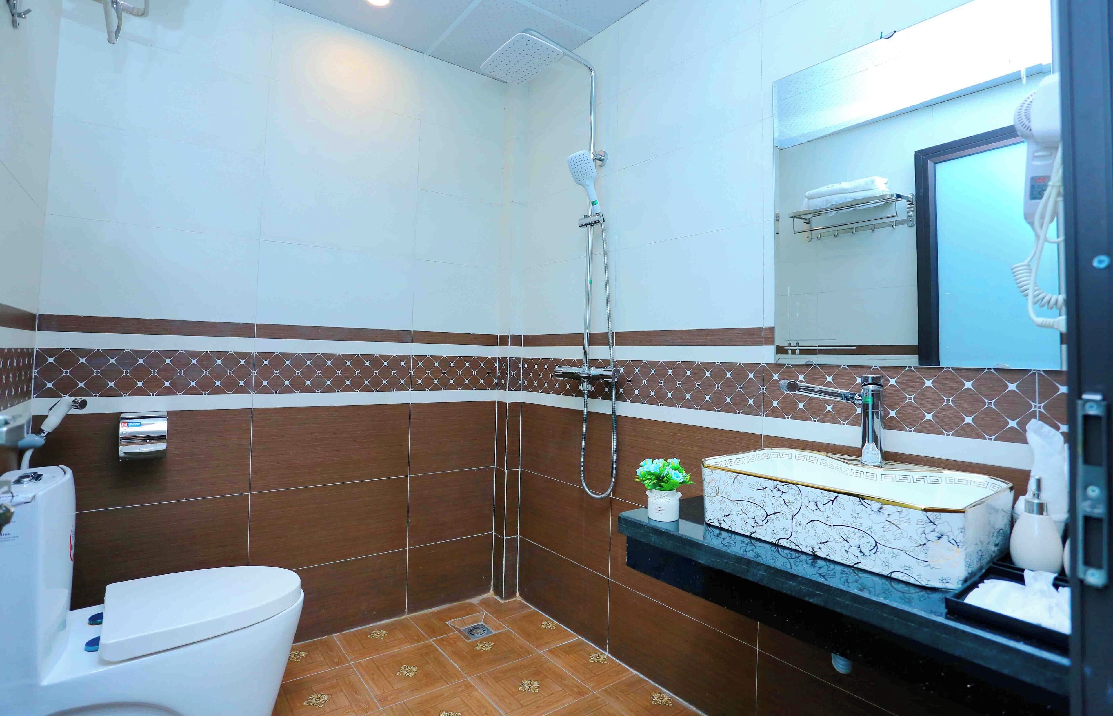 A bathroom with a shower, toilet, and sink.