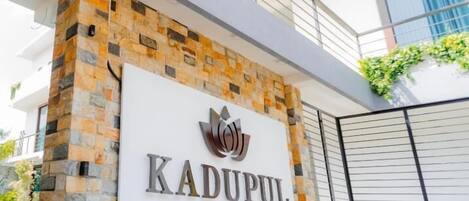 Una entrada de edificio con fachada de piedra y un letrero que dice "KADUPUL BY SERENITY".