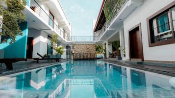 Una piscina al aire libre, sillones reclinables de piscina