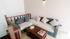 A living room with a sofa, a coffee table, and a wooden side table. - KADUPUL By Serenity (Negombo)