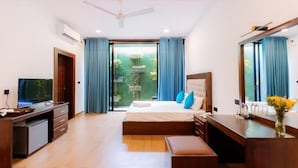 A modern hotel room with a bed, a desk, a TV, and a balcony with curtains. - KADUPUL By Serenity (Negombo)